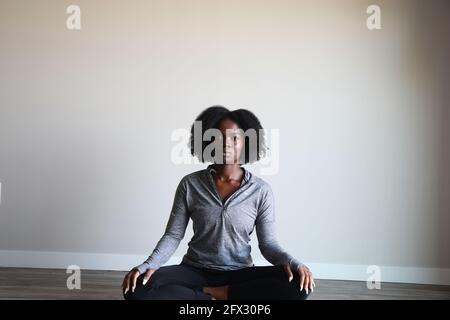 Portrait d'une jeune femme à la peau sombre et attrayante en vêtements de sport méditant à l'intérieur, une personne, santé, vie active, afro-américain, Banque D'Images