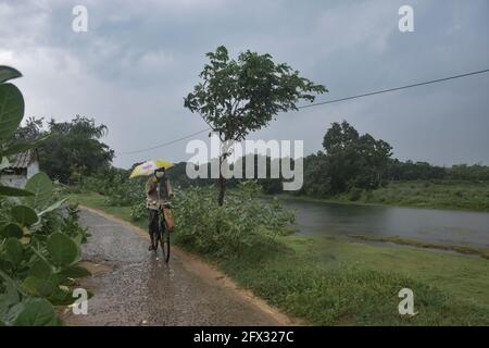 Hoogly, Inde. 25 mai 2021. Un homme vu à vélo sous la pluie avant la chute du cyclone 'Yaas'.Cyclone 'Yaas' fera probablement une chute au milieu des zones côtières de Balastore et Digha le 26 mai, mercredi matin. En tant que tempête cyclonique très grave, elle peut causer de fortes précipitations dans les districts côtiers du Bengale occidental et du nord de l'Odisha. (Photo par Tamal Shee/SOPA Images/Sipa USA) crédit: SIPA USA/Alay Live News Banque D'Images