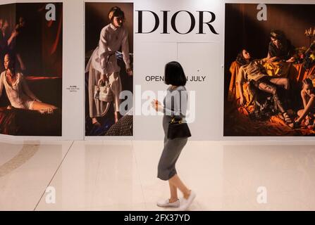 Une femme passe devant le magasin Christian Dior de produits de luxe, de vêtements et de beauté français en cours de rénovation à Hong Kong. Banque D'Images