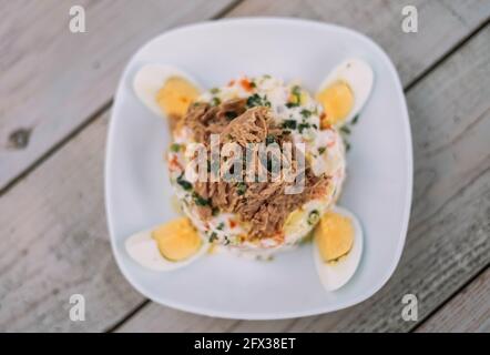 Salade russe avec thon, pommes de terre, œuf dur, petits pois, carottes et mayonnaise Banque D'Images