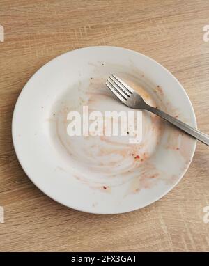 Assiette et fourchette sales vides après le dîner sur une table en bois Banque D'Images
