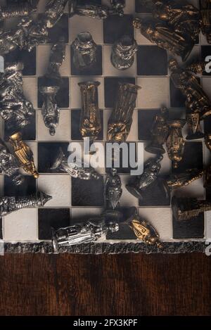 pièces d'échecs stylisées sur un tableau avec fond noir, fumée et vue de dessus Banque D'Images