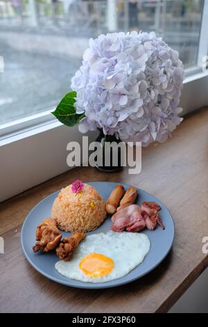 Petit-déjeuner américain - riz frit avec œufs frit, ailes de poulet, jambon et saucisses Banque D'Images