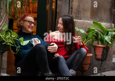 Deux femmes entrepreneurs d'âge moyen assises à l'entrée de leur boutique. Concept: Entrepreneur féminin, amitié féminine Banque D'Images