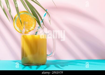 Jus d'orange dans un verre sur un arrière-plan coloré avec espace de copie. Banque D'Images