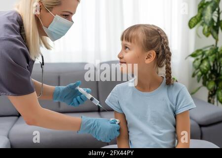 Peu de fille obtenant la vaccination de pédiatre à medical office Banque D'Images