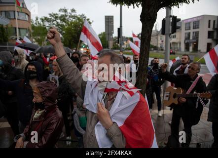 Varsovie, Varsovie, Pologne. 25 mai 2021. Un homme lève son poing et tient des drapeaux biélorusses historiques le 25 mai 2021 à Varsovie, en Pologne. Près d'une centaine de personnes se sont rassemblées à côté de l'ambassade du Bélarus pour réclamer la liberté des prisonniers politiques détenus en Biélorussie après l'arrestation de Roman Protasevich, un éminent journaliste de l'opposition biélorusse. Crédit: Aleksander Kalka/ZUMA Wire/Alay Live News Banque D'Images