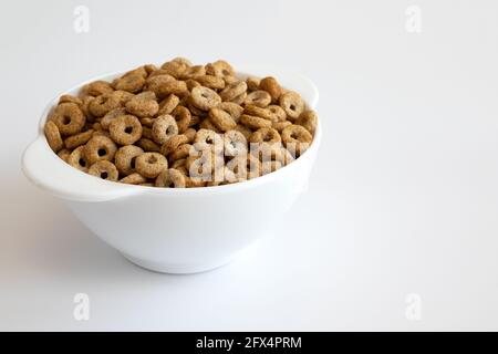 céréales cheerios dans un bol isolé sur fond blanc, assiette de délicieux anneaux, concept de petit déjeuner sain Banque D'Images