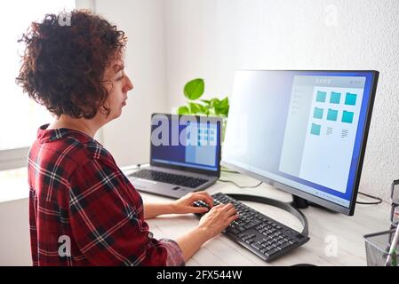 Femme tapant sur un clavier d'ordinateur à la lumière du jour Banque D'Images