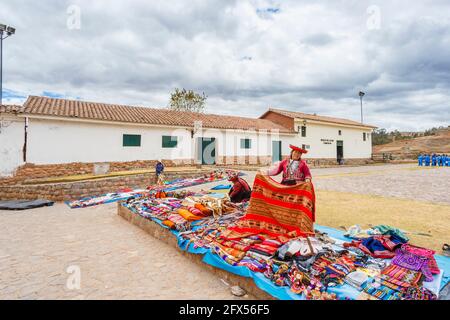 Marché extérieur de textiles et de souvenirs sur la place de la ville de Chinchero, un village rustique andin dans la Vallée Sacrée, Urubamba, région de Cusco, Pérou Banque D'Images