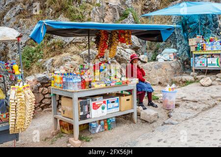 Une femme âgée et un stand de collations à Chinchero, un petit village rustique andin de la vallée Sacrée, province d'Urubamba, région de Cusco, Pérou Banque D'Images