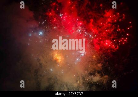 Une explosion colorée de feux d'artifice et de fumée dans le noir Ciel nocturne Banque D'Images