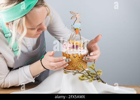 Moscou, Russie - 18 avril 2021 : un chef pâtissier décore un gâteau de Pâques avec une composition en bois sous forme de lièvre. Banque D'Images