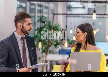 Le responsable explique à son employé comment terminer ses tâches. Collègues discutant d'un projet en se tenant dans un bureau. Banque D'Images