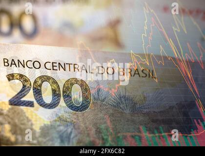 Dans cette photo illustration, deux cents reais note vu affiché avec un graphique de la bourse en arrière-plan, le réel est la monnaie du Brésil. La Banque centrale a lancé des lignes directrices pour la création d'une monnaie numérique qui servira d'extension du réel dans le pays. Banque D'Images