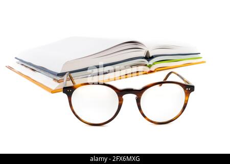 Lunettes de lecture et pile de livre ouvert isolée sur fond blanc Banque D'Images