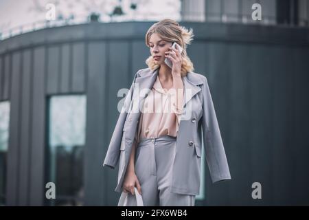 Femme en costume professionnel avec smartphone près de l'oreille Banque D'Images