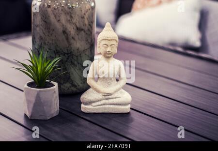 Statue de Bouddha sur table grise. Intérieur moderne de style Hugge. Banque D'Images