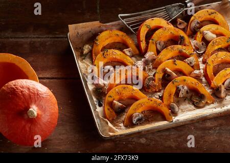 Par-dessus des tranches de citrouille orange cuites sur la cuisson faire revenir avec de l'ail et des champignons sur la table Banque D'Images