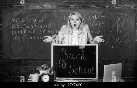 L'école. L'enseignement à domicile. surpris femme. Retour à l'école. Journée des enseignants. enseignant avec réveil au tableau noir. Le temps. femme en classe. L'éducation et de l'étude Banque D'Images