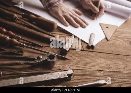 Menuisier professionnel travaillant sur un projet créatif et des outils vintage Banque D'Images