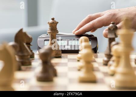 Joueur d'échecs frapper l'horloge d'échecs: Tournoi d'échecs et concept de compétition Banque D'Images