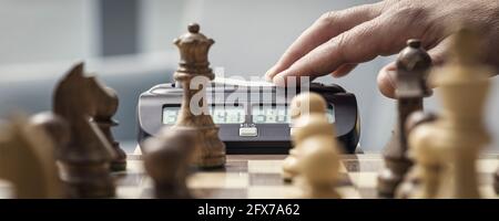 Joueur d'échecs frapper l'horloge d'échecs: Tournoi d'échecs et concept de compétition Banque D'Images