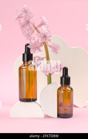 Deux flacons bruns avec compte-gouttes avec huiles essentielles ou sérum avec fleurs de jacinthe. Concept de soins et de beauté Banque D'Images