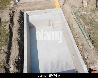 Tir de drone du chantier de construction de la piscine où la piscine est déjà finie remplie, plâtré sans feuille d'aluminium dans un jardin en autriche Banque D'Images