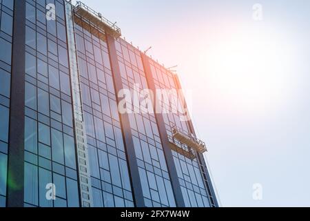Construction suspendue à cheval près du mur du bâtiment résidentiel de highttower avec façade moderne en métal de verre. Ingénierie ville urbaine Banque D'Images