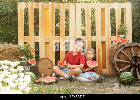 Les enfants heureux mangent de la pastèque en plein air en été. Pique-nique. Banque D'Images