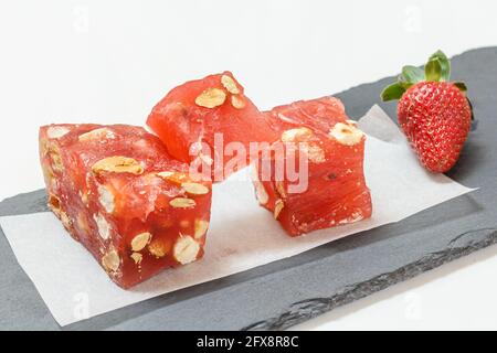 Bonbons aux fruits avec noix et fraise sur fond blanc. Banque D'Images