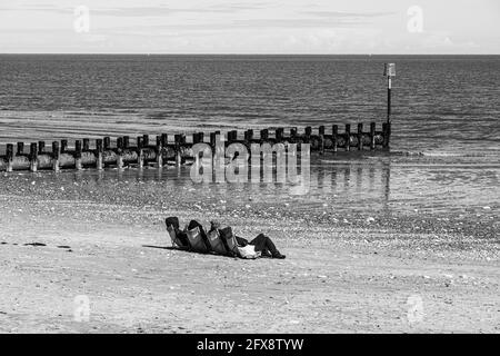 Quatre personnes bronzer au milieu du mois d'avril près de la mer du Nord à Bridlington, East Riding of Yorkshire, Angleterre Royaume-Uni. Version couleur 2FX8W2A. Banque D'Images