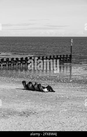 Quatre personnes bronzer au milieu du mois d'avril près de la mer du Nord à Bridlington, East Riding of Yorkshire, Angleterre Royaume-Uni. Version couleur 2FX8W58. Banque D'Images