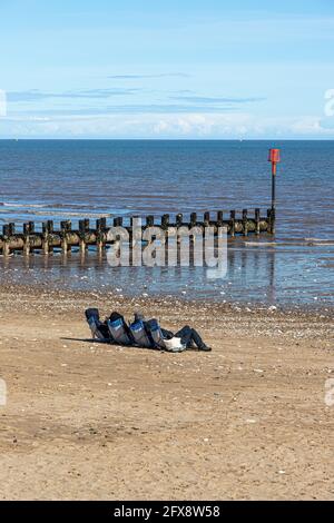 Quatre personnes bronzer au milieu du mois d'avril près de la mer du Nord à Bridlington, East Riding of Yorkshire, Angleterre Royaume-Uni. Version noir et blanc 2FX8W4 Banque D'Images