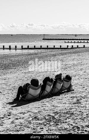 Quatre personnes bronzer au milieu du mois d'avril près de la mer du Nord à Bridlington, East Riding of Yorkshire, Angleterre Royaume-Uni. Version couleur 2FX8W9J. Banque D'Images