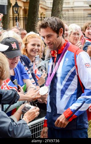 Mark Hunter montrant au public sa médaille d'argent d'aviron en tant qu'athlètes olympiques de l'équipe GB quittant Buckingham Palace après le défilé de la victoire. Jeux olympiques de Londres 2012 Banque D'Images