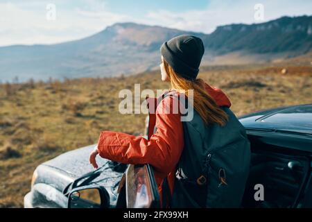 une femme voyage dans la nature avec un sac à dos et près du voiture Banque D'Images