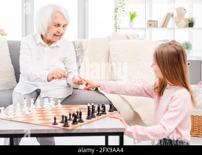 Fille jouant aux échecs avec grand-mère