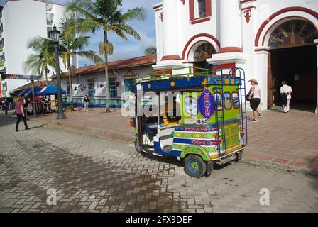 Tuk tuk tuk sur la place principale avec l'église notre-Dame de Carmen, Guatape, Colombie, Amérique du Sud Banque D'Images