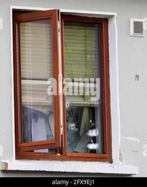 Des policiers de police inspectent des trous de balle dans une fenêtre sur les lieux de tournage à l'ouest de Dublin, où deux détectives qui ont répondu à des rapports de coups de feu ont été tués et blessés mardi soir après que Gardai ait été appelé dans la région de Blanchardstown à Dublin et a été mis en feu. Les détectives armés, tous deux dans leurs 30 ans, ont échangé le feu avec un homme à l'intérieur d'une propriété et les deux officiers blessés ont été abattus dans le pied et l'un a également une blessure à la main. Date de la photo: Mercredi 26 mai 2021. Un homme à la fin des années 30 a été arrêté et est détenu à la gare de Blanchardstown Garda en vertu de l'article 30 de la loi sur les infractions contre l'État. Banque D'Images