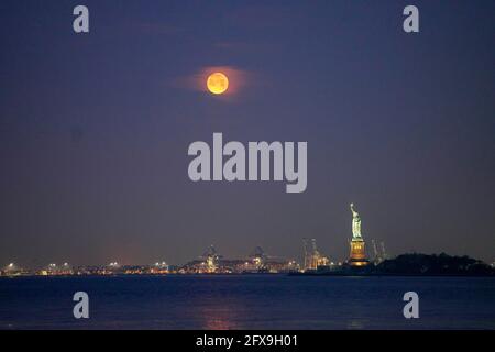 New York, États-Unis. 26 mai 2021. Une lune est vue au-dessus de la Statue de la liberté à New York, aux États-Unis, le 26 mai 2021. Une super lune a pu être observée mercredi dans certaines parties des États-Unis. Crédit : Wang Ying/Xinhua/Alay Live News Banque D'Images