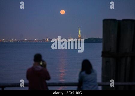 New York, États-Unis. 26 mai 2021. Une lune est vue au-dessus de la Statue de la liberté à New York, aux États-Unis, le 26 mai 2021. Une super lune a pu être observée mercredi dans certaines parties des États-Unis. Crédit : Wang Ying/Xinhua/Alay Live News Banque D'Images