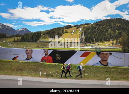 Seefeld, Autriche. 26 mai 2021. Les randonneurs passent les écrans avec des photos des joueurs de l'équipe nationale allemande de football, en dessous des sauts de ski dans l'un des deux terrains de football que l'équipe nationale utilisera pendant leur camp d'entraînement dans le Tyrol avant la finale du Championnat d'Europe. Credit: Christian Charisius/dpa - ATTENTION: Utiliser seulement en format complet/dpa/Alamy Live News Banque D'Images