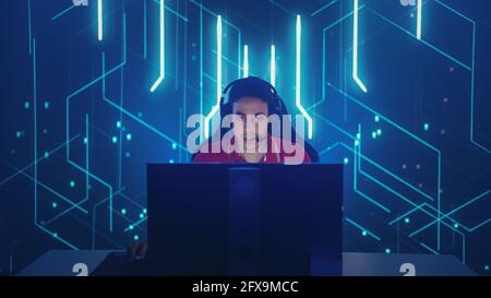 Professionnel eSports joueur jouant dans les jeux vidéo d'ordinateur, joyeusement et joyeusement célèbre la victoire et le succès. Cyber-championnat en ligne Banque D'Images