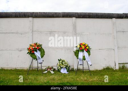 26 mai 2021, Saxe-Anhalt, Hötensleben: Des couronnes couchées se tiennent sur le mur du mémorial de la frontière de Hötensleben. La cérémonie de dépôt des couronnes a eu lieu le 69e anniversaire de l'établissement du régime frontalier de la RDA et des réinstallations forcées connexes de la zone réglementée. Le 26 mai 1952, un décret de police a été publié sur la base duquel une zone restreinte de 5 kilomètres de large, une zone de protection de 50 mètres de large et une bande de contrôle de 10 mètres de large ont été établies le long de la frontière intérieure allemande. La clôture initiale de la planche et la bande de contrôle ont été encore étendues dans les années suivantes. U Banque D'Images