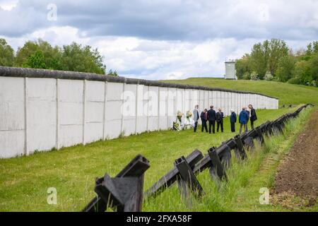 26 mai 2021, Saxe-Anhalt, Hötensleben: Participants à un stand de cérémonie de pose de couronne au mur du mémorial de la frontière de Hötensleben. La cérémonie de dépôt des couronnes a eu lieu le 69e anniversaire de l'établissement du régime frontalier de la RDA et des réinstallations forcées connexes de la zone réglementée. Le 26 mai 1952, un décret de police a été publié sur la base duquel une zone restreinte de 5 kilomètres de large, une zone de protection de 50 mètres de large et une bande de contrôle de 10 mètres de large ont été établies le long de la frontière intérieure allemande. La clôture initiale de la planche et la bande de contrôle ont été encore étendues en TH Banque D'Images