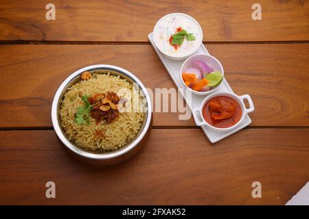 Veg Biriyani, garni d'oignon frit, feuille de coriandre et noix de cajou frite dans un ancien récipient en laiton avec cornichon de citron, salade de légumes, ratha Banque D'Images