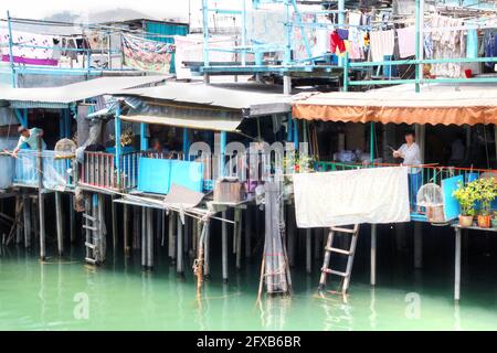 HONG KONG-avr. 10, 2011: Les résidents de Tai O pêchant à partir de leurs maisons sur pilotis au-dessus des appartements de marée de l'île de Lantau à Hong Kong. Maison de la Tanka Banque D'Images