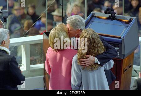 Le président des États-Unis William Jefferson Clinton embrasse sa femme, Hillary, et embrasse sa fille Chelsea après avoir prêté serment pour son second mandat au Capitole des États-Unis le lundi 20 janvier 1997. Le sénateur américain John Warner (républicain de la Virginie) est à gauche. Crédit : Ron Sachs / CNP / MediaPunch Banque D'Images